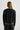 Person wearing a black outfit with gray trim on a white background