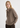 Woman wearing a brown sweater with a tie-neck design on a white background
