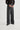 Person wearing a black shirt and gray wide-leg pants on a white background