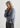 Woman wearing a light gray sweater against a white background