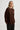 Person wearing a brown sweater against a white background