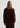 Person wearing a brown sweater and black pants against a white background