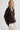 Woman wearing a brown cardigan against a plain background