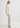 Woman wearing a white outfit on a plain background