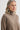 Woman wearing a beige turtleneck sweater against a white background