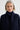 Woman wearing a dark blue coat against a plain background