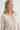 Woman wearing a beige cardigan against a white background