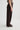 Person wearing dark brown wide-leg pants on a light gray background