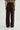 Person wearing dark brown wide-leg pants on a white background