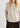 Woman wearing a beige sweater and dark pants on a white background