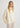 Woman wearing a cream sweater against a white background