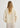 Person wearing a beige sweater and pants on a white background