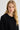 Woman wearing a black sweater against a white background