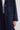 Navy blue coat with button details on a light gray background