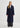 Woman wearing a long navy coat on a white background