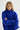 Woman wearing a blue sweater against a white background