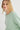 Woman wearing a light green sweater against a white background