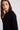 Woman wearing a black sweater against a white background